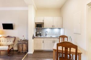 a kitchen with white cabinets and a table and chairs at Nostalgie Apartment in Kerken