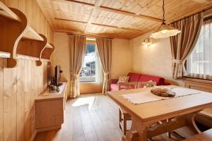 a living room with a table and a red couch at Chalet La Fiamma in Santa Caterina Valfurva +35 photos