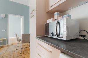 a kitchen with a microwave on top of a counter at GuestHost - Chic Flat Steps from Duomo in Milan +16 photos