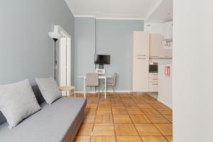a living room with a couch and a kitchen at GuestHost - Chic Flat Steps from Duomo in Milan
