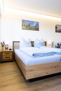 a bedroom with a large wooden bed with blue sheets at Höri-Nest Abendsonne-Appartement in Gaienhofen