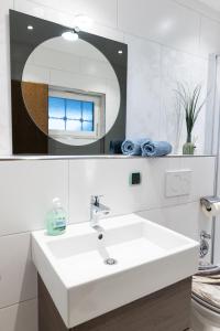 a white bathroom with a sink and a mirror at Höri-Nest Abendsonne-Appartement in Gaienhofen +22 photos