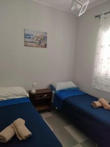 a bedroom with two beds and a night stand and a window at Villetta Roby in Marina di Modica