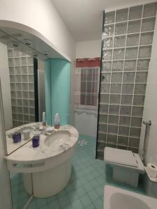 a bathroom with a sink and a toilet and a mirror at Villetta Roby in Marina di Modica +17 photos