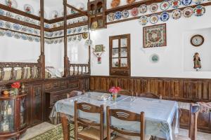 a dining room with a table and plates on the wall at Villa Houvarda in Karpathos