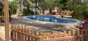 a swimming pool in a yard with a wooden fence at El Pinar de la Loma in Moratalla