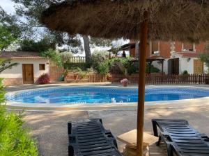 a swimming pool with two chairs and an umbrella at El Pinar de la Loma in Moratalla