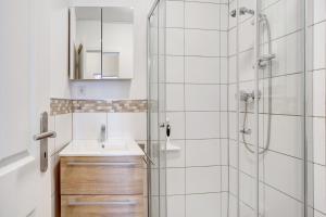 a white bathroom with a sink and a shower at Fereinwohnung am Marktplatz in Warendorf +15 photos