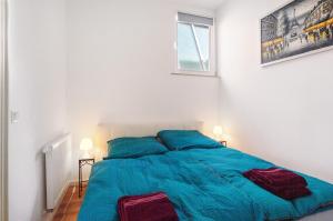 a bed with blue sheets in a white bedroom at Fereinwohnung am Marktplatz in Warendorf