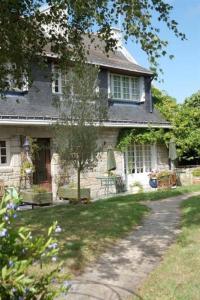 a stone house with a table and chairs in the yard at Le Goéland in Sarzeau