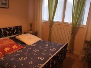 a bedroom with a bed and a window with curtains at Le Goéland in Sarzeau
