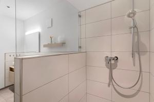 a shower in a bathroom with white tiles at Ferienwohnung Rebenrain, 80qm in Steinach +20 photos