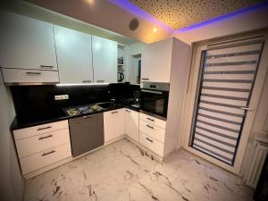 an empty kitchen with white cabinets and a window at Deluxe - Apartment 'Andrei 2' in Neuburg an der Donau