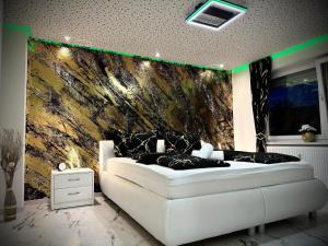 a bedroom with a white bed and a wall at Deluxe - Apartment 'Andrei 2' in Neuburg an der Donau