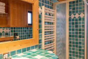 a bathroom with blue tiled walls and a sink at Appartement les 4 As in Megève