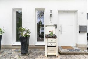 a dresser with flowers on it in front of a door at Ferienwohnung Kleeblatt in Herbolzheim