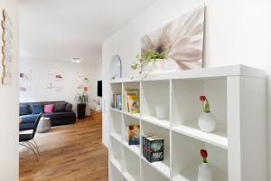 a living room with white shelves and a couch at Ferienwohnung Kleeblatt in Herbolzheim