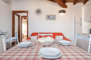 a dining room with a table with plates on it at Appartamento Zeus in Tanaunella