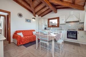 a kitchen and living room with a table and a couch at Appartamento Zeus in Tanaunella