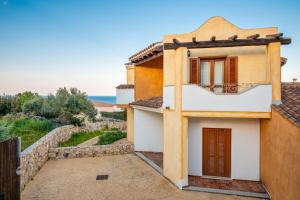 a building with a balcony and the ocean in the background at Appartamento Zeus in Tanaunella