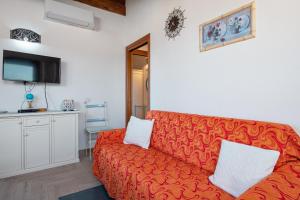 a living room with a red couch and a tv at Appartamento Zeus in Tanaunella