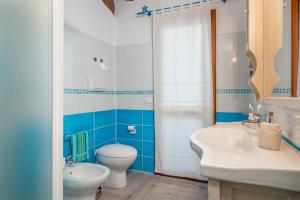 a blue and white bathroom with a toilet and a sink at Appartamento Zeus in Tanaunella +18 photos
