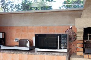 a microwave sitting on a counter next to a toaster oven at Appart Côte bleue avec jardin in Martigues