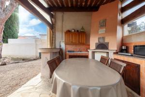 a kitchen with a table with chairs and a stove at Appart Côte bleue avec jardin in Martigues
