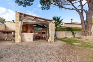 a building with an open garage in front of a house at Appart Côte bleue avec jardin in Martigues