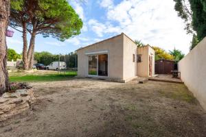 a small white house with a tree in the yard at Appart Côte bleue avec jardin in Martigues +13 photos