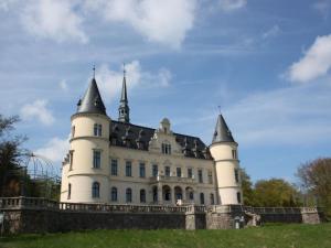 a white castle with black towers on top of a field at Ferienhaus Melody in Ralswiek