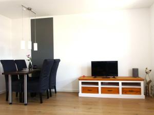 a dining room with a table and a television on a cabinet at Ferienhaus Melody in Ralswiek