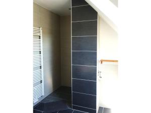 a bathroom with a walk in shower with blue tiles at Ferienhaus Melody in Ralswiek +13 photos