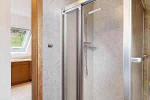 a shower with a glass door in a bathroom at Bergbauernhof 1910 in Oberharmersbach +126 photos
