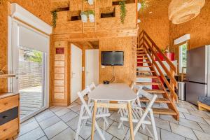 a dining room with a table and chairs and a staircase at Les chalets de Piqueyrot in Hourtin