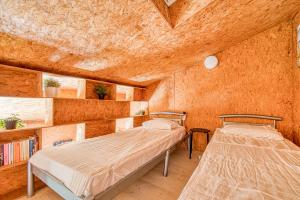 a bedroom with two beds in a room with a ceiling at Les chalets de Piqueyrot in Hourtin