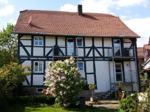 a white and black house with a red roof at Gästehaus Minkel in Gudensberg