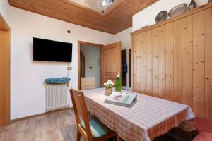 a dining room with a table and a television at Regalterhof Eppan in San Paolo
