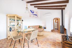 a living room with a table and chairs and a couch at Can Titina in Puigpunyent