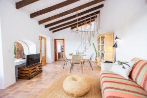 a living room with a couch and a tv and a table at Can Titina in Puigpunyent