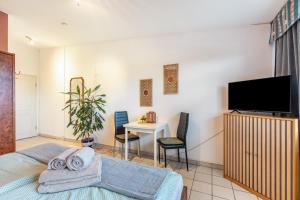 a bedroom with a bed and a tv and a table at Albrechtshof in Potsdam