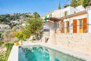 a villa with a swimming pool and a house at Can Titina in Puigpunyent