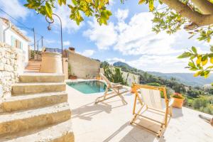 a villa with a swimming pool and two chairs at Can Titina in Puigpunyent