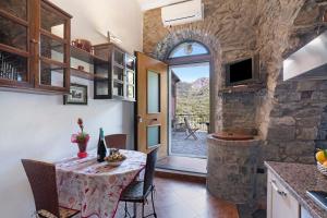 a kitchen and dining room with a table and a door at Appartamento Aurora in Corniglia