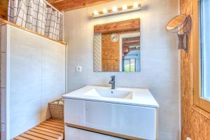 a bathroom with a sink and a mirror at Les chalets de Piqueyrot in Hourtin +39 photos