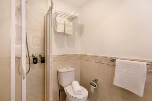 a bathroom with a toilet and a shower with towels at Capelos in Funchal +24 photos