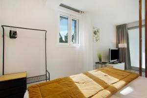 a white bedroom with a bed and a window at Capelos in Funchal