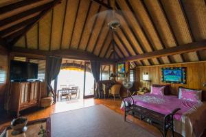a bedroom with a bed and a tv in a room at Bora Bora Bungalove in Bora Bora