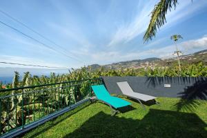two chairs on a balcony with a view of the ocean at Capelos in Funchal