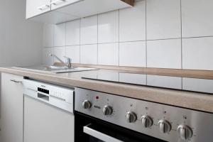 a white kitchen with a stove and a sink at Ferienwohnung Laage in Laage